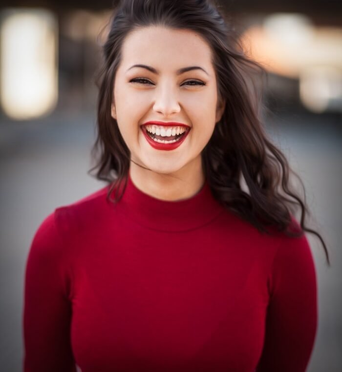 A woman smiling at the camera indoors
